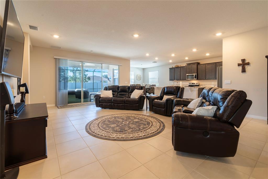 8284 Southwest 59th Terrace Ocala, FL 34476 - Photo 6 of 63 a living room with furniture a rug and a flat screen tv