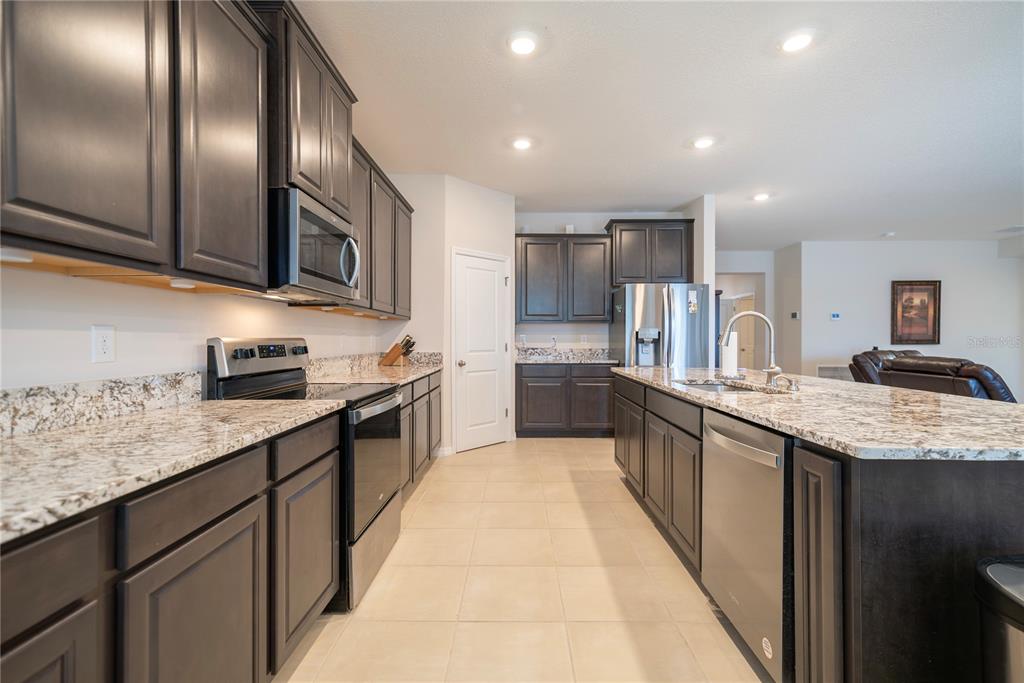 8284 Southwest 59th Terrace Ocala, FL 34476 - Photo 10 of 63 a large kitchen with stainless steel appliances granite countertop a large counter top and a stove top oven