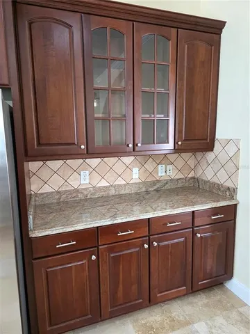 a large kitchen with granite countertop a sink and cabinets