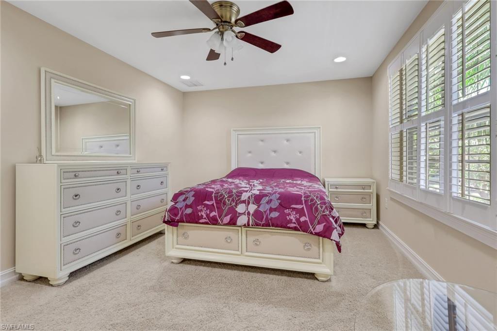 16309 Aberdeen Way Naples, FL 34110 - Photo 20 of 34 a spacious bedroom with a bed and a chandelier