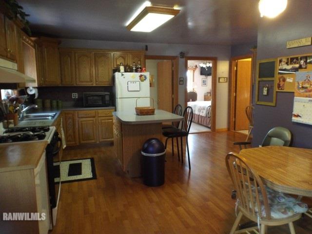8011 Haas Road Savanna, IL 61074 - Photo 2 of 36 a kitchen with stainless steel appliances kitchen island granite countertop a table chairs in it and wooden floors