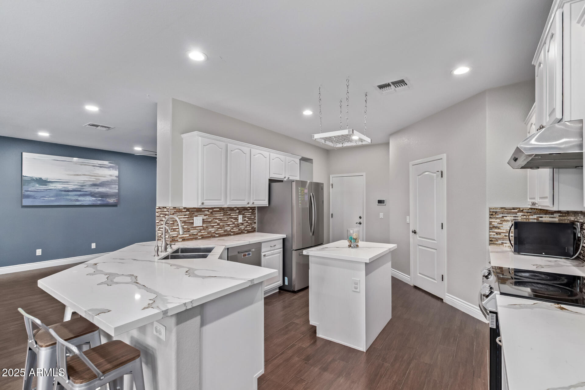 2225 West Carter Road Phoenix, AZ 85041 - Photo 11 of 33 a kitchen with a refrigerator a stove a sink dishwasher with a dining table and chairs