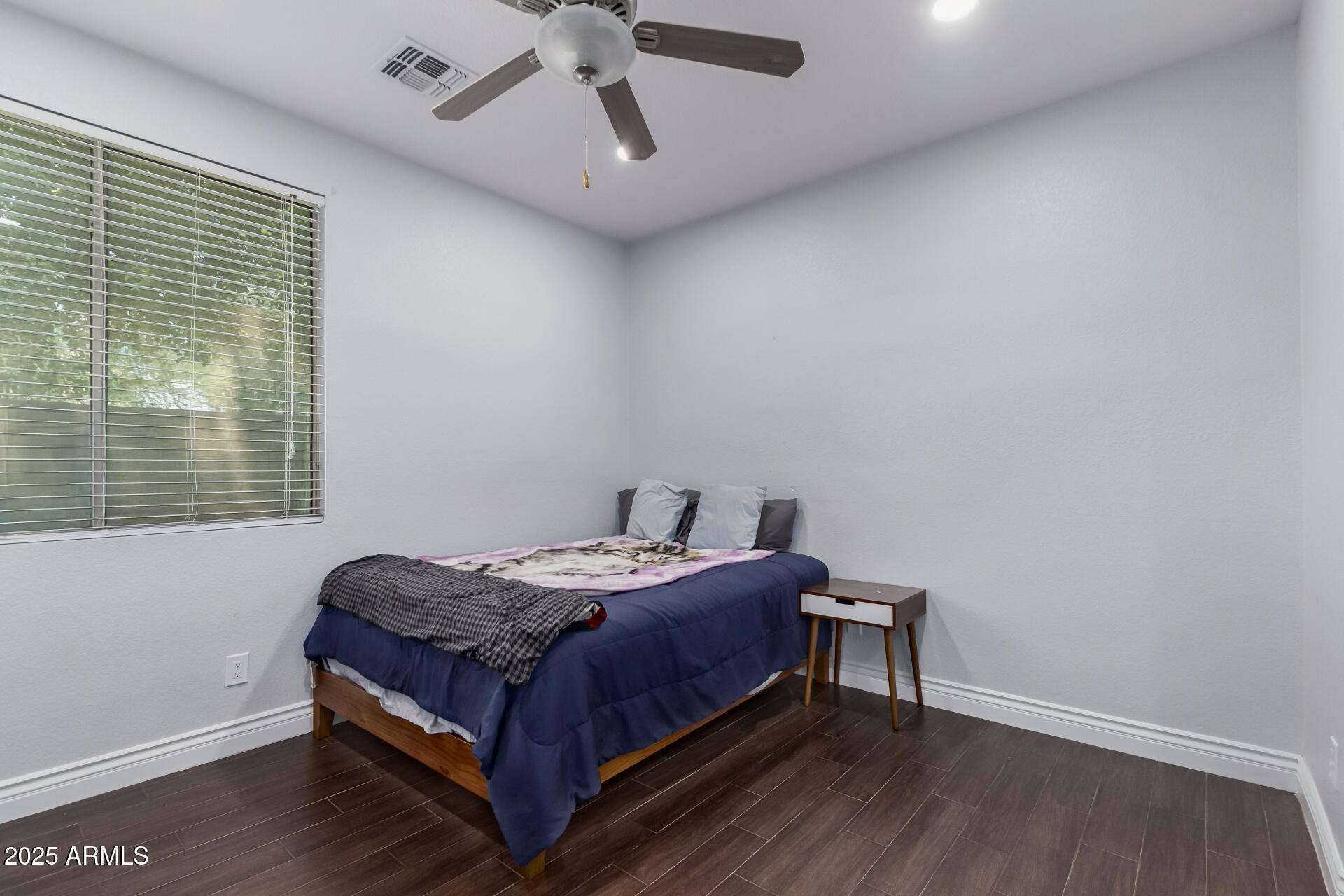 2225 West Carter Road Phoenix, AZ 85041 - Photo 20 of 33 a bed sitting in a bedroom next to a window