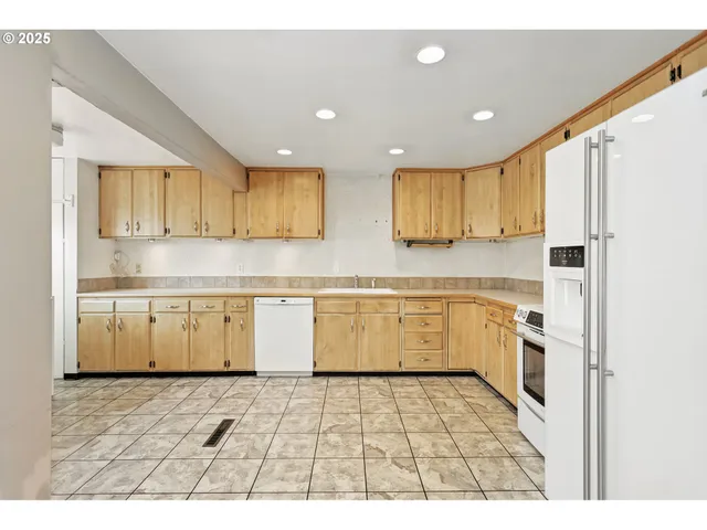 a kitchen with granite countertop a refrigerator and a sink