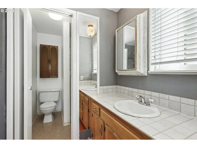 a bathroom with a granite countertop sink a mirror and a bathtub