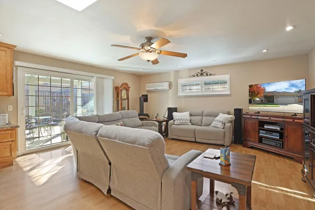 a living room with furniture a flat screen tv and a floor to ceiling window