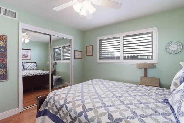 a bedroom with a bed and a table in it with wooden floor
