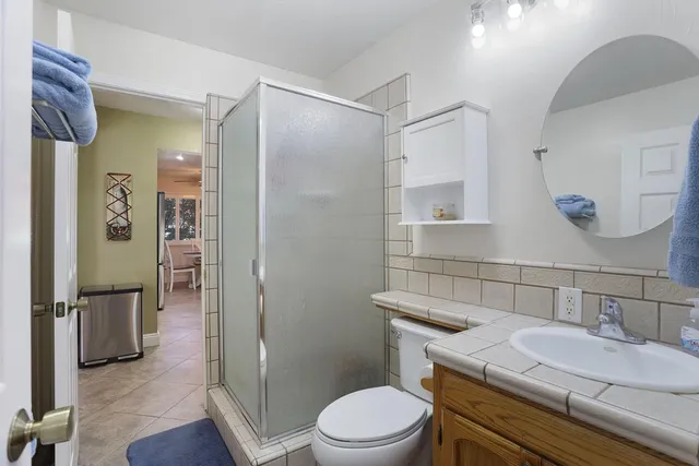 a bathroom with a sink a toilet and shower