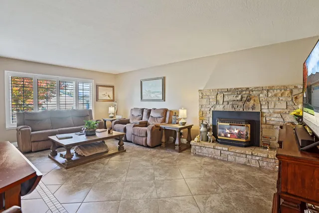 a living room with furniture large window and a fireplace