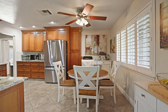 a view of a dining room with furniture a chandelier and large window