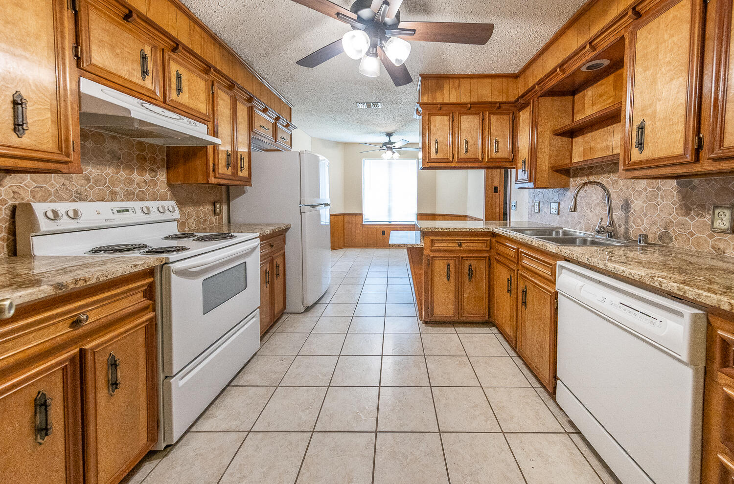 4828 73rd Street Lubbock, TX 79424 - Photo 8 of 23 a kitchen with stainless steel appliances granite countertop a stove a sink and a microwave