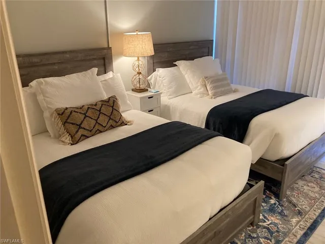 a bed room with two bed and a night stand