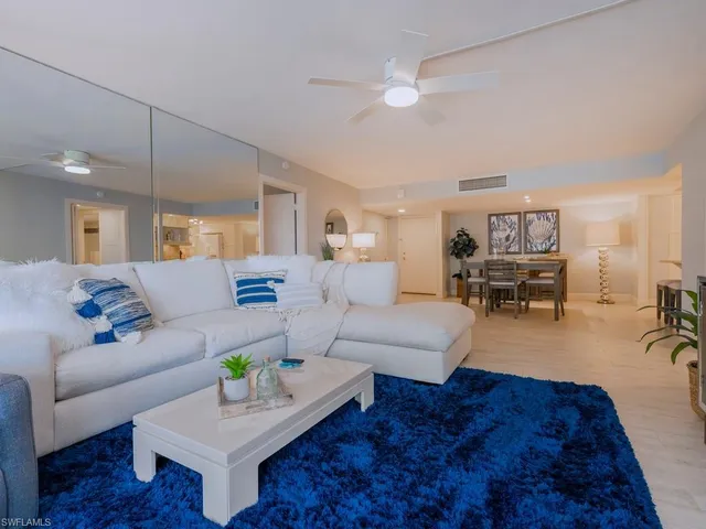 a living room with furniture and a view of kitchen