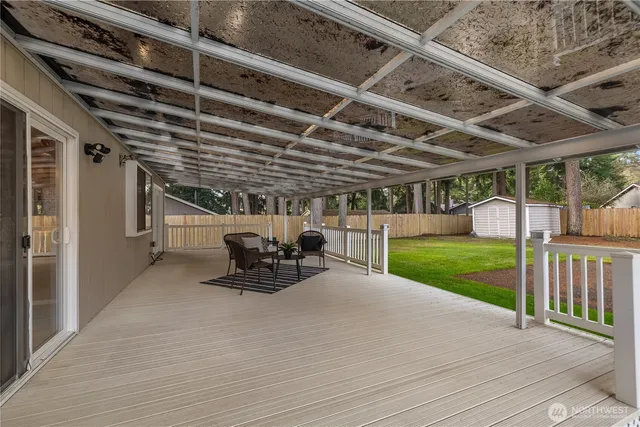 a view of a patio with table and chairs with wooden floor and fence