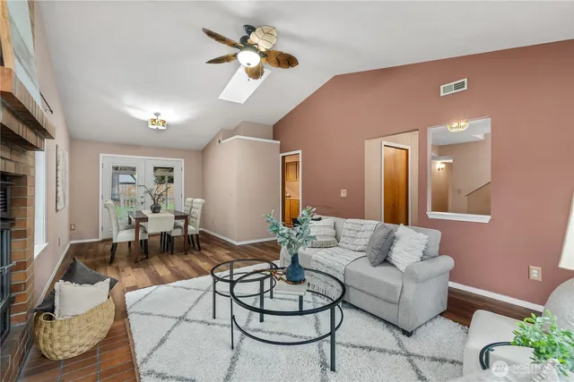 a living room with furniture kitchen view and a chandelier