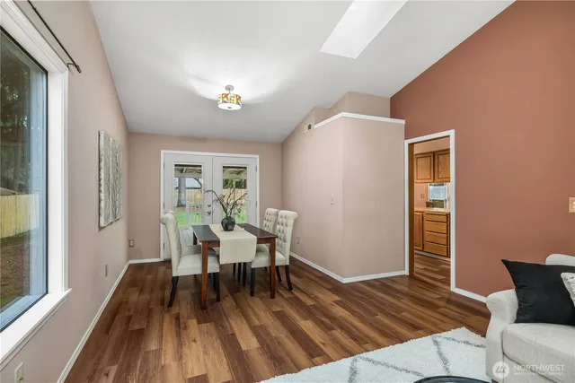 a view of a livingroom with wooden floor and furniture