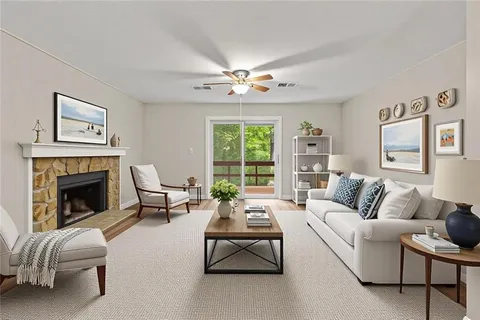 a living room with furniture fireplace and a large window