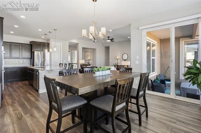 a open kitchen with stainless steel appliances granite countertop wooden cabinets a refrigerator a stove a sink and a oven with wooden floor