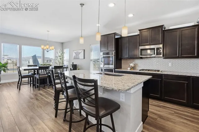 a kitchen with granite countertop a sink a counter top space and living room view