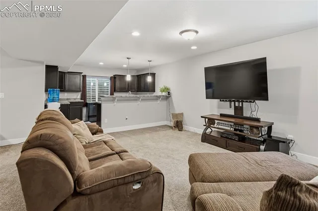 a living room with furniture and a large mirror with potted plants