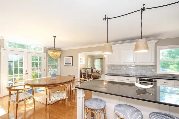 a kitchen with kitchen island a stove a table and chairs in it