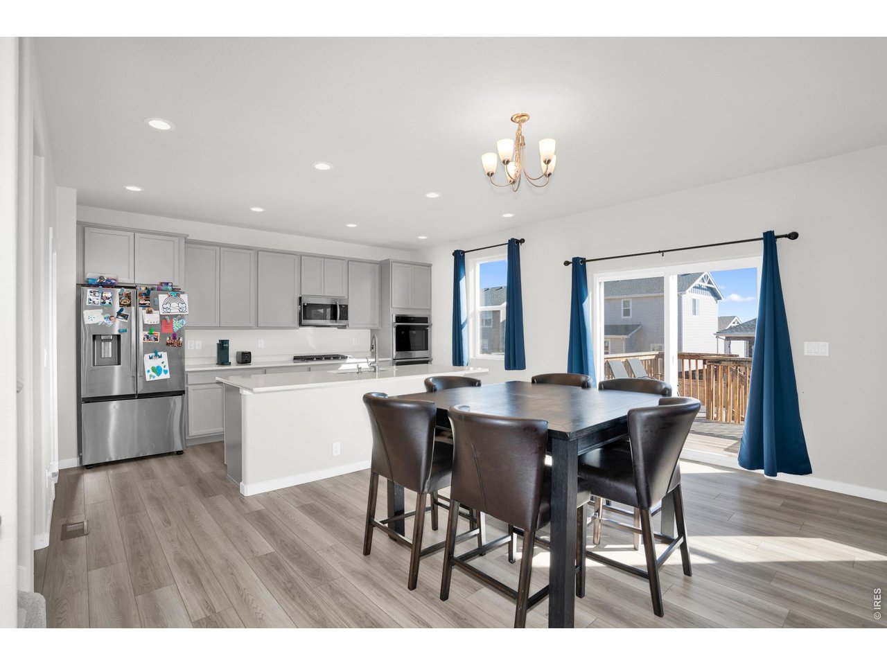 864 Frst Cyn Road Severance, CO 80550 - Photo 10 of 39 a open dining room with stainless steel appliances kitchen island granite countertop a dining table chairs and a refrigerator