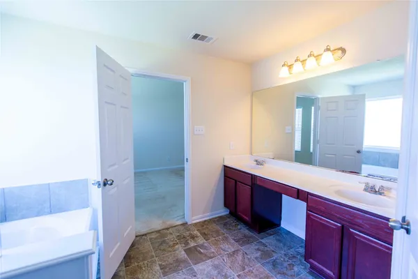 a spacious bathroom with a bathtub sink and mirror