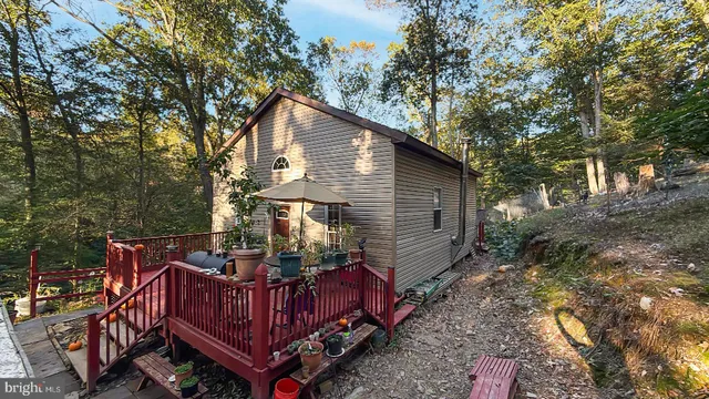 a view of a house with a wooden deck and furniture