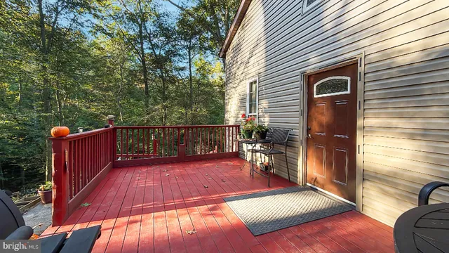 a view of a backyard with wooden floor and iron fence