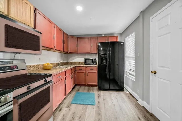 a kitchen with stainless steel appliances granite countertop a refrigerator stove and sink