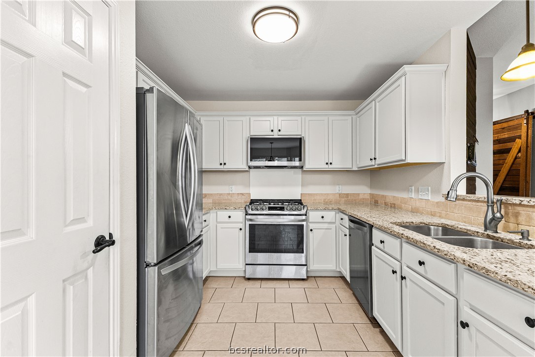 3709 Springfield Drive College Station, TX 77845 - Photo 6 of 23 a kitchen with stainless steel appliances granite countertop a stove top oven a sink and a refrigerator