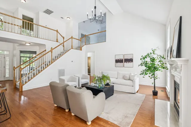 a dining room with furniture wooden floor a chandelier and a mirror
