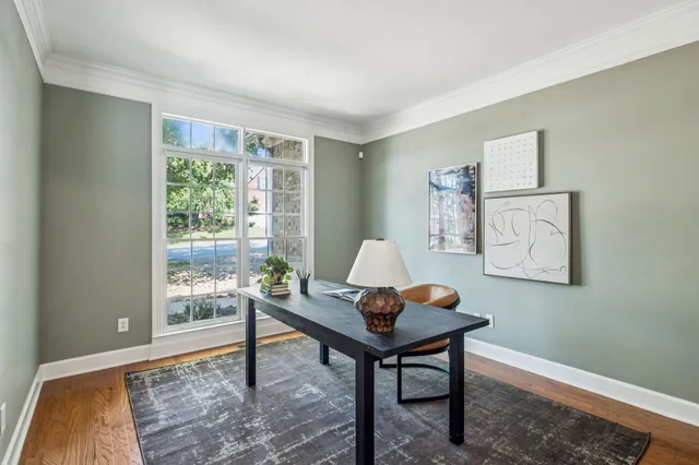 a kitchen with stainless steel appliances a dining table chairs and wooden floor