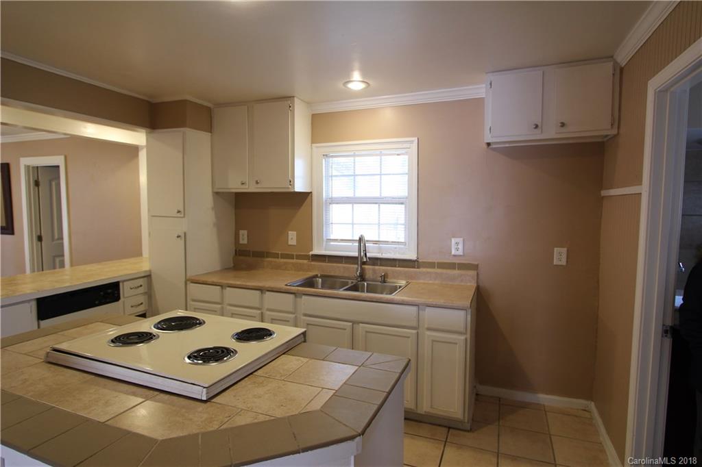 6616 Charlie Walker Road Kannapolis, NC 28081 - Photo 7 of 16 a kitchen with kitchen island a stove a sink and a refrigerator