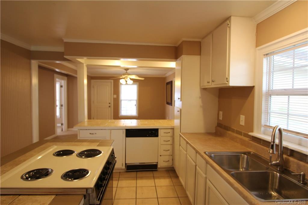 6616 Charlie Walker Road Kannapolis, NC 28081 - Photo 9 of 16 a kitchen with a sink a stove cabinets and a window