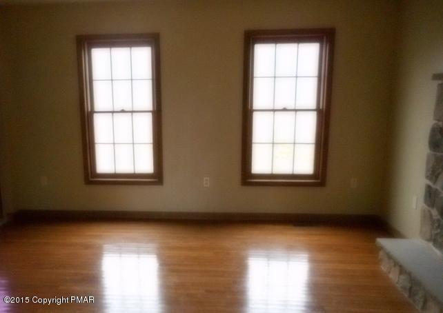 258 Lehman Road Bushkill, PA 18324 - Photo 2 of 8 an empty room with wooden floor and windows