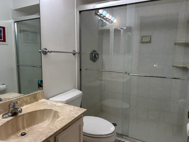 a bathroom with a sink a toilet and shower