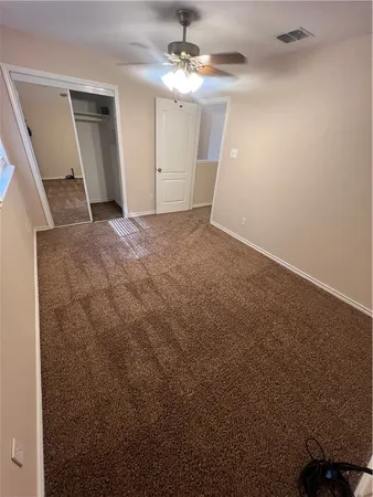 en empty room with windows and fan