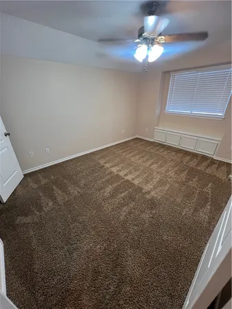 a view of a room with a ceiling fan and a window