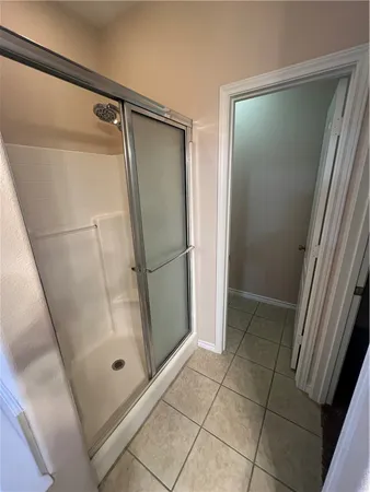a bathroom with a glass door shower and a sink