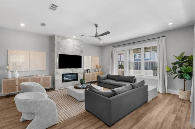 a living room with furniture flat screen tv and a large window