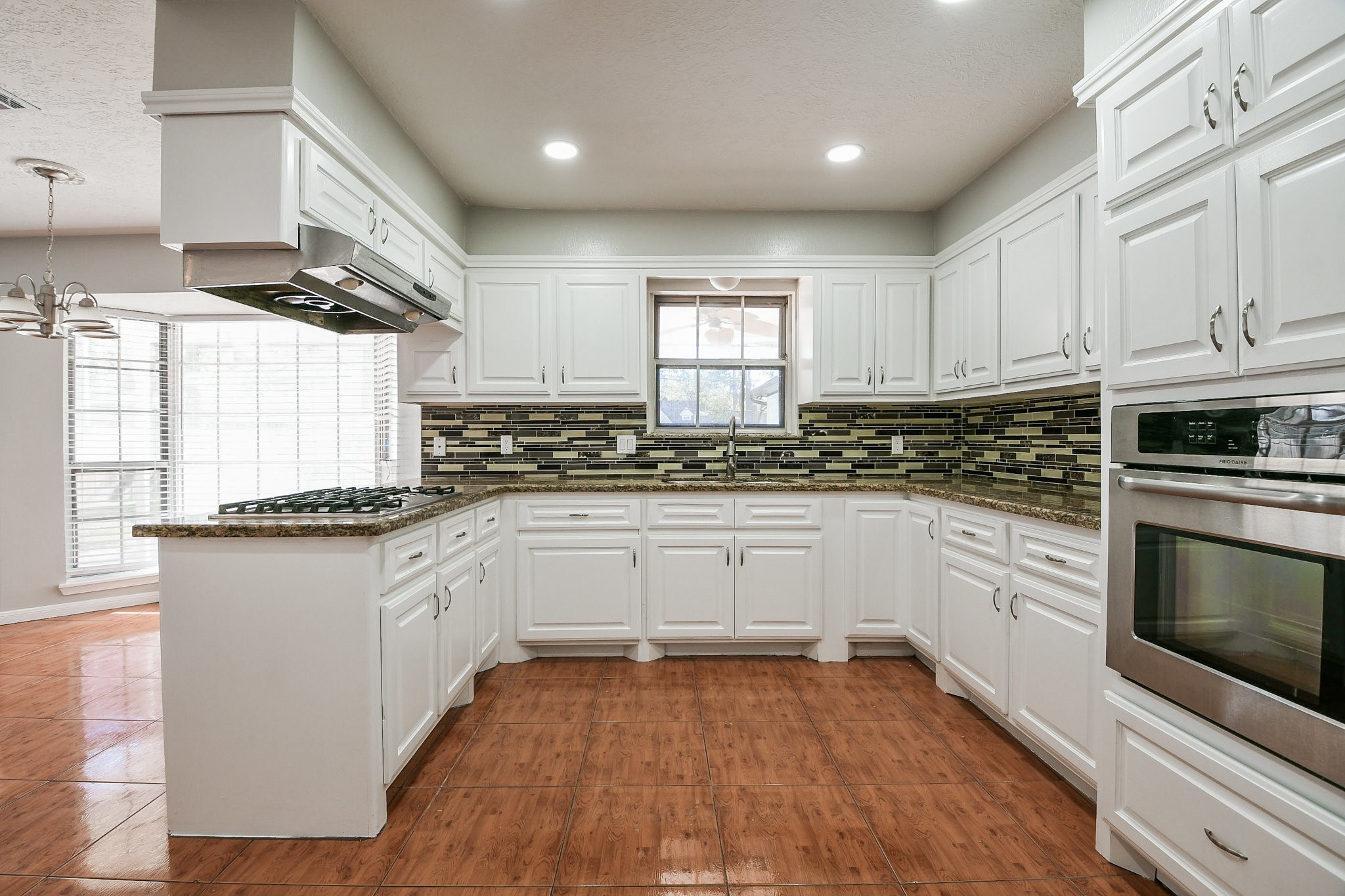 1007 Maranon Lane Houston, TX 77090 - Photo 15 of 36 a kitchen with granite countertop white cabinets and white appliances