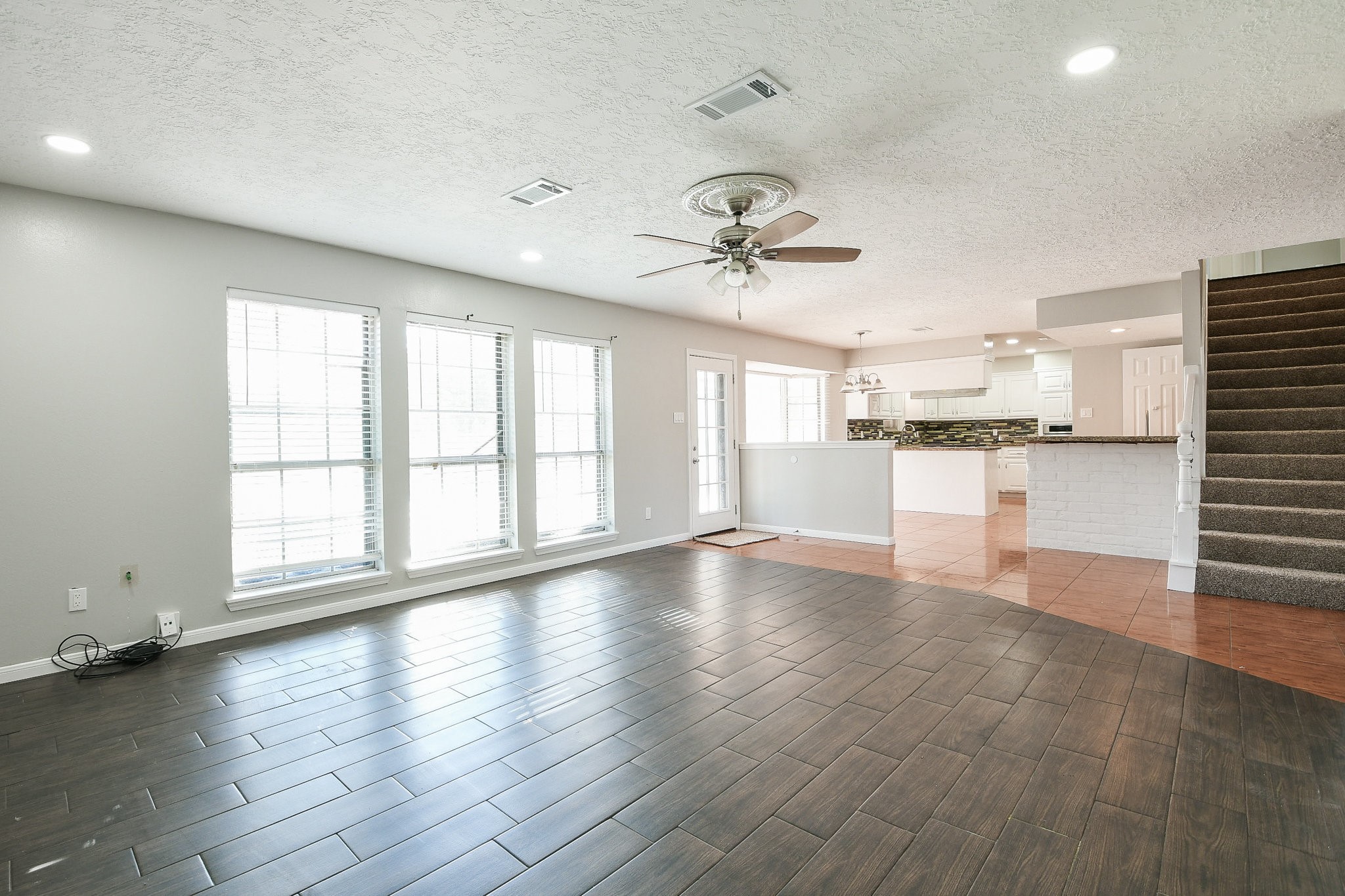 1007 Maranon Lane Houston, TX 77090 - Photo 8 of 36 a view of an empty room with a kitchen and wooden floor