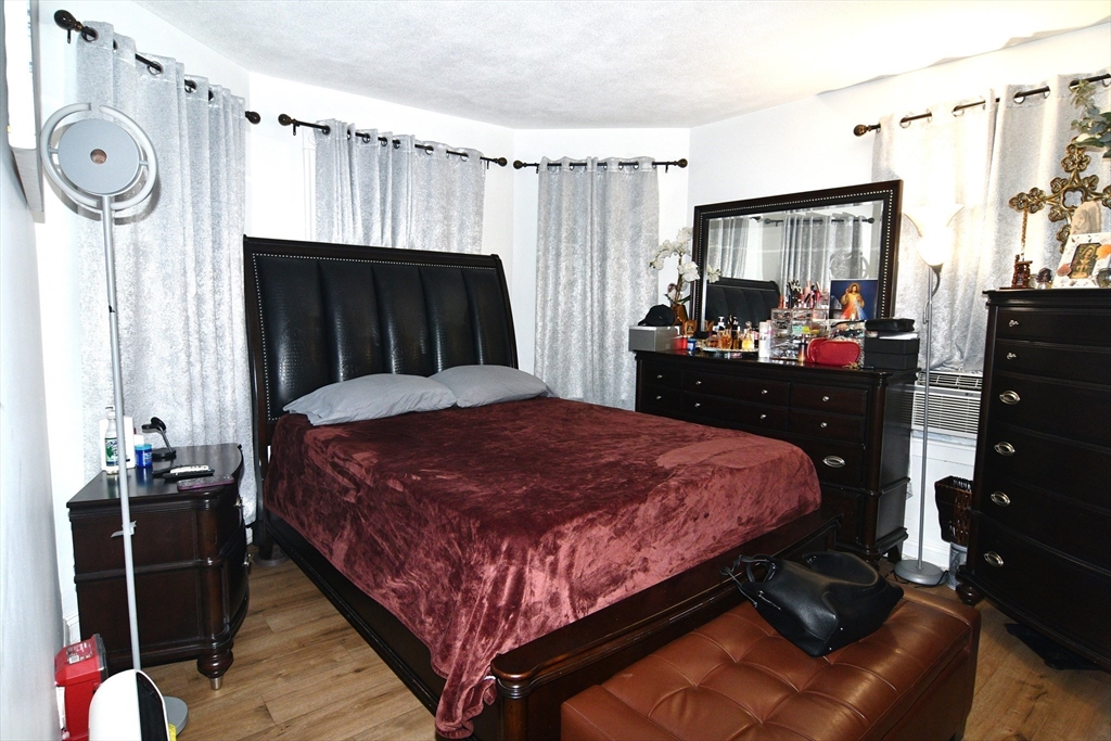 121 Cottage Street Everett, MA 02149 - Photo 14 of 35 a bedroom with a bed closet and a mirror