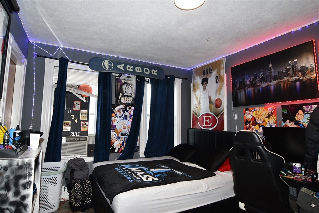 121 Cottage Street Everett, MA 02149 - Photo 16 of 35 a bedroom with a bed and a wall painting