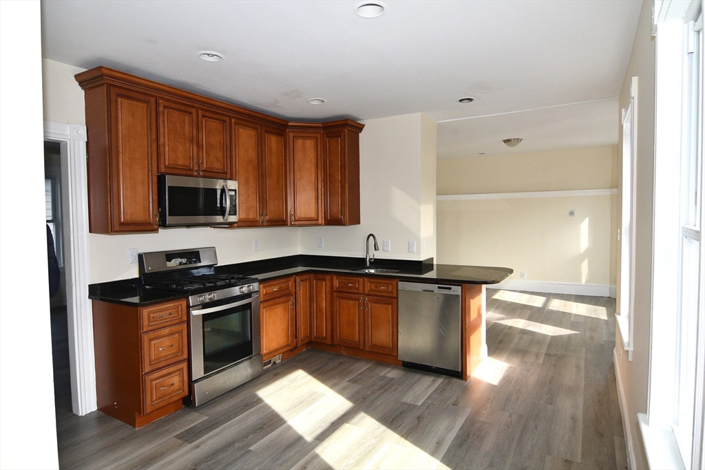 121 Cottage Street Everett, MA 02149 - Photo 18 of 35 a kitchen with stainless steel appliances a stove a sink and a microwave