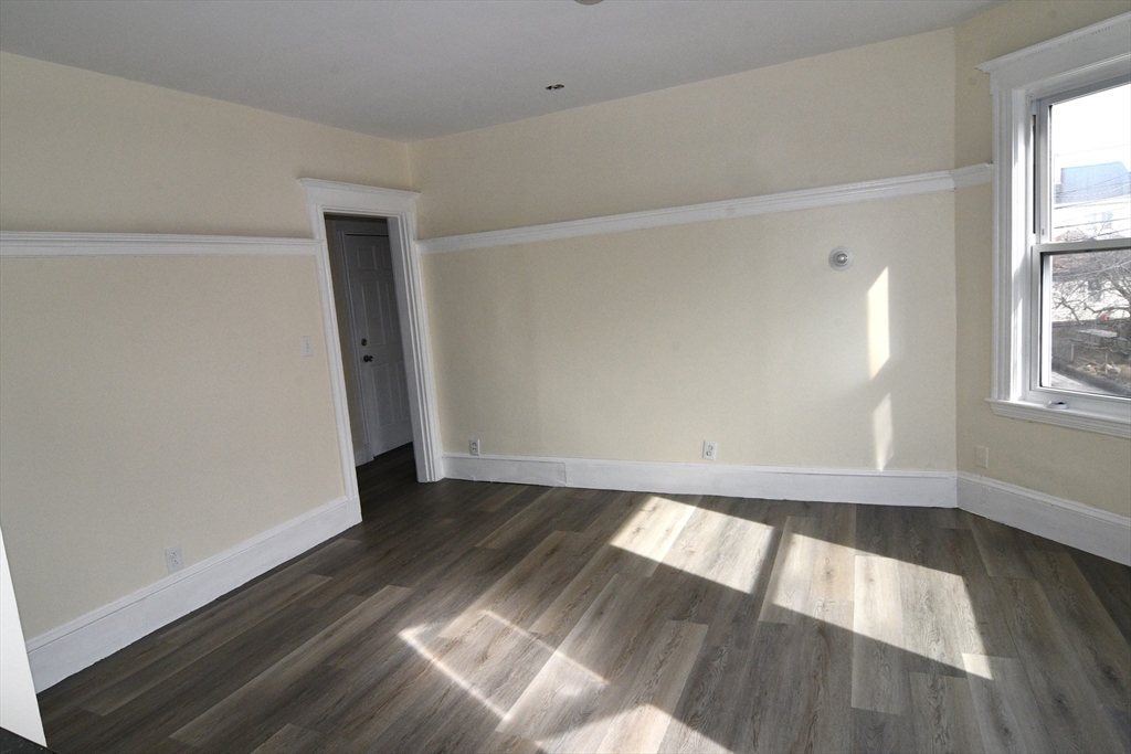 121 Cottage Street Everett, MA 02149 - Photo 20 of 35 an empty room with wooden floor and windows