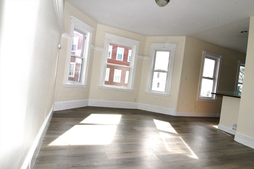 121 Cottage Street Everett, MA 02149 - Photo 21 of 35 an empty room with wooden floor and windows