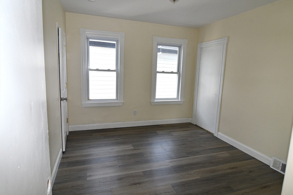 121 Cottage Street Everett, MA 02149 - Photo 23 of 35 an empty room with wooden floor and windows