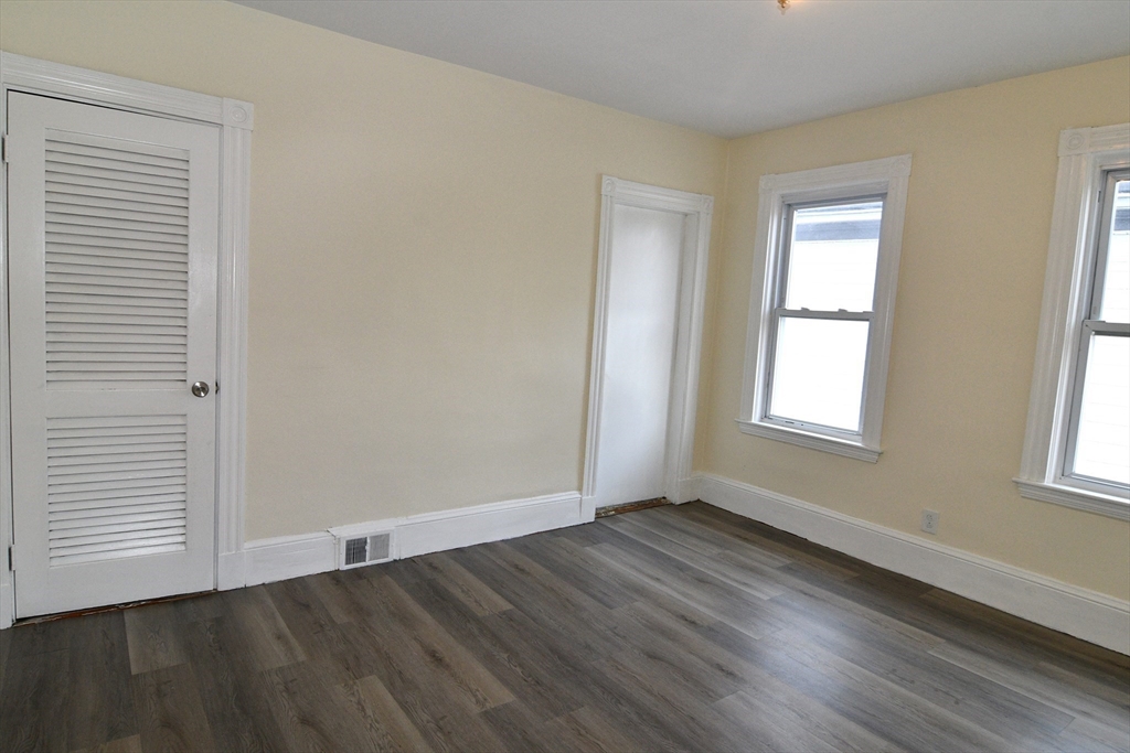 121 Cottage Street Everett, MA 02149 - Photo 24 of 35 an empty room with wooden floor and windows